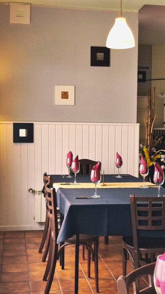 mesa en el comedor del asador Edan, copas de cristal con servilletas de color granate, mantel negro