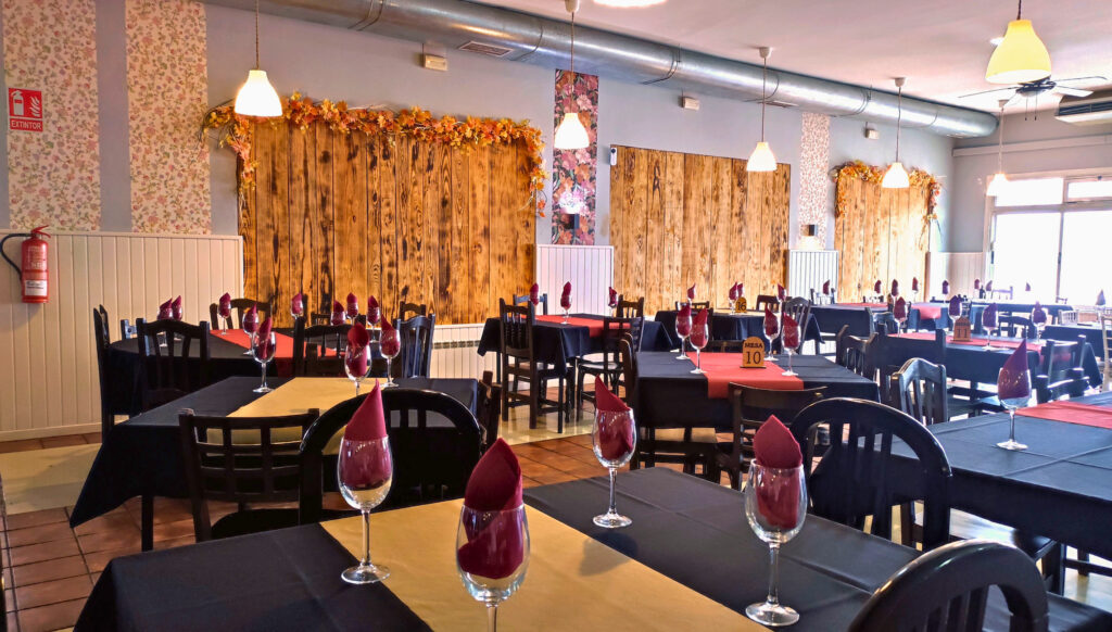 sala comedor del Asador Edan con mesas preparadas con manteles, cubiertos y copas