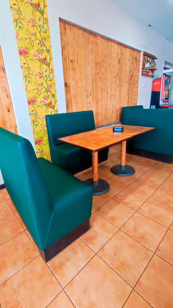mesa de madera con sofás alrededor en la cafetería bar del asador Edan
