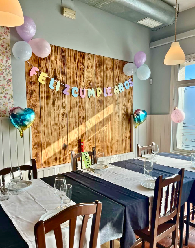 zona del comedor del asador Edan preparada para un evento con decoración de cumpleaños y globos en las paredes